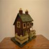 Large Wood Standing Birdhouse Decoration Resembling a Red Barn with a Fence Around the Green Checkered Yard and Pink Roses on the Green Checkered Roof; There Are Three (3) Access Holes for Birds and Large Nesting Area Inside of the Barn. Measurements view 3