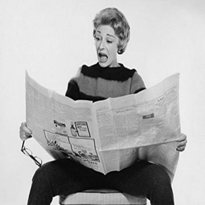 Mid adult woman reading a newspaper and looking surprised Poster Print (18 x 24)