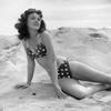 1950s-1960s Brunette Bathing Beauty Stretched Out On Sand Wearing Polka-Dot Bikini Looking At Camera Print By Vintage view 1