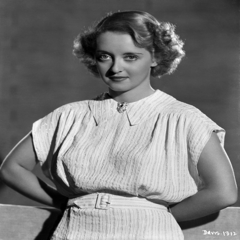 Bette Davis Posed with Hands on the Back in White Short Sleeve Knitted Cotton Dress and White Belt Photo Print (24 x 30)