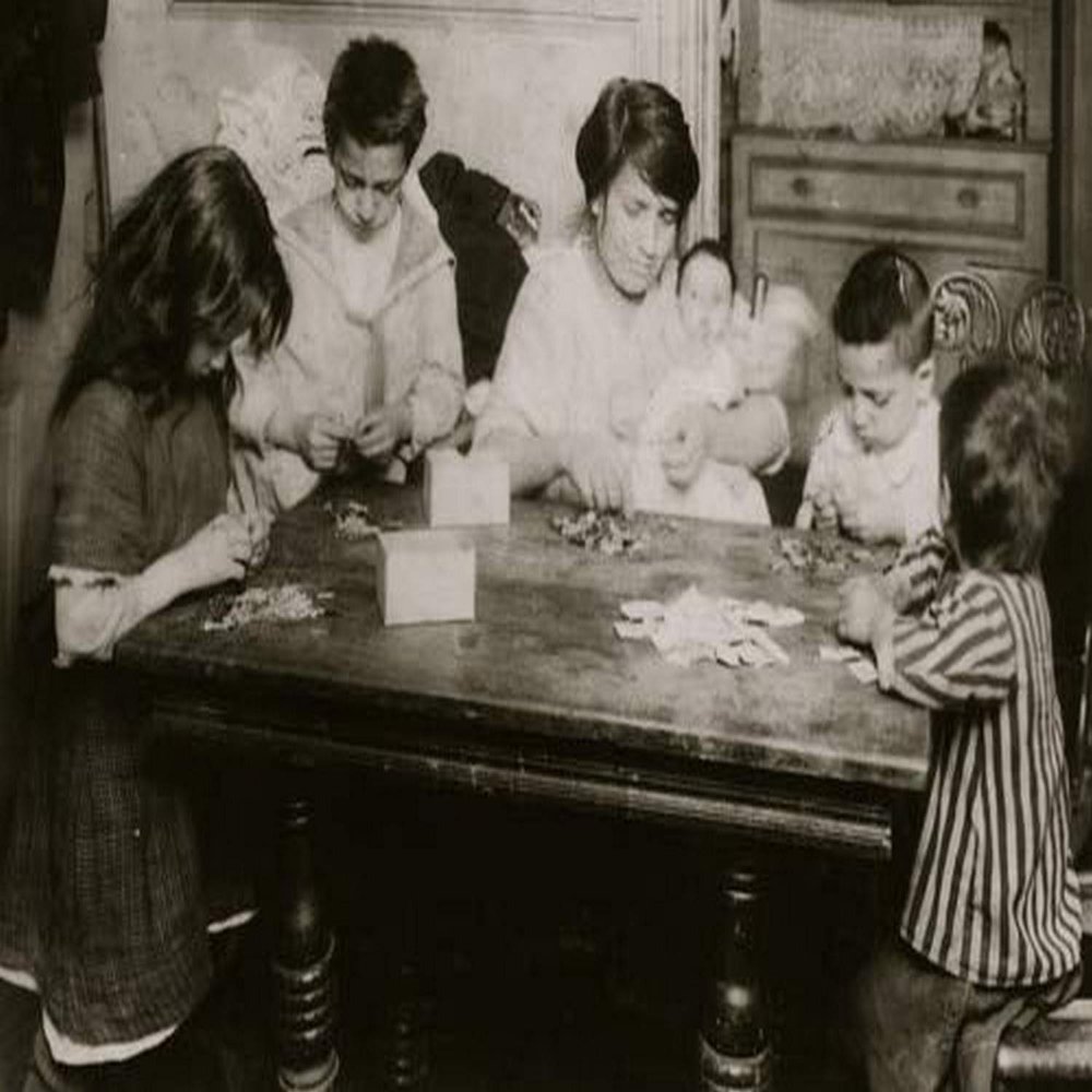 Civarro family 2106 Second Avenue second floor back working on patriotic flag pins They get 3 cents a gross for inserting pin and putting onto card Mrs Civarro with her three-months-old baby in her ar