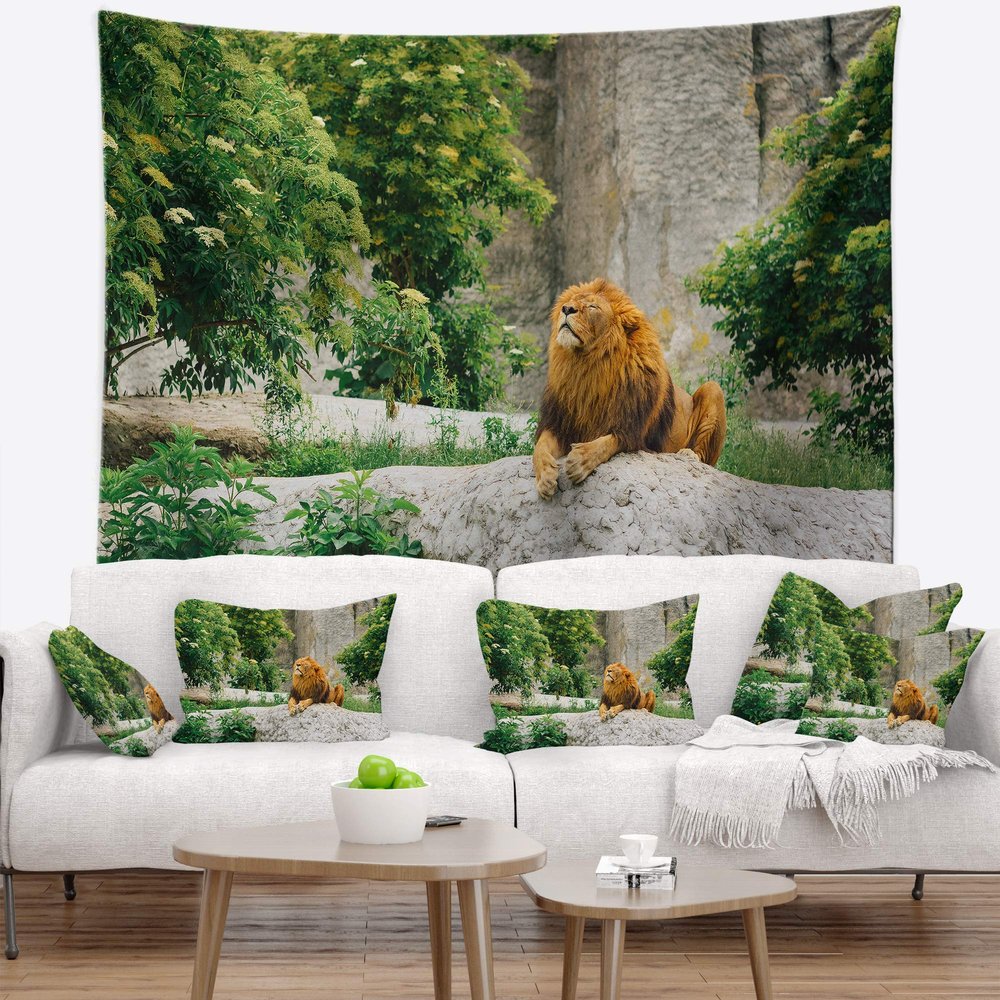 Designart ' Big Lion Lying On Stones in Zoo' Landscape Tapestry Blanket Dcor Wall Art for Home and Office X-Large: 92 in. x 78 in