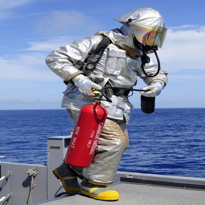 Posterazzi Firefighter carries a CO2 fire extinguisher onto the flight deck of USS Denver Poster Print, (12 x 16)