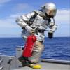 Posterazzi Firefighter carries a CO2 fire extinguisher onto the flight deck of USS Denver Poster Print, (12 x 16) view 1