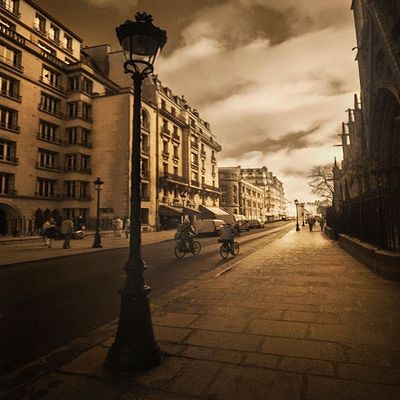 Bicycle riders beside Notre Dame Cathedral and her gargoyles in Paris-France by Steve Mohlenkamp -