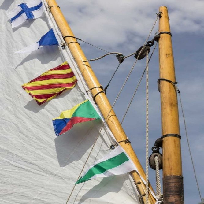 WA, Boat sail and flags at Bainbridge Island by Don Paulson -